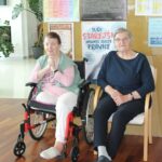 Stanovalki doma za starejše sedita v skupnem prostoru ob dnevu aktivnosti in druženja.