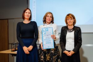 Predstavnica Doma upokojencev Ptuj na podelitvi drži certifikat »Družini prijazno podjetje«.