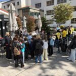 Učenci in stanovalci doma za starejše sodelujejo na družabnem srečanju na zunanji terasi doma.