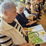 Stanovalke doma za starejše sodelujejo pri glasbeni dejavnosti ob petju ljudskih pesmi.