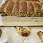 Narezani kosi pečene potice so postreženi na pladnju in papirnatih prtičkih.