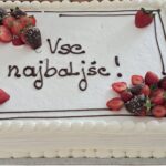 Torta z napisom »Vse najboljše!« in okrasom iz jagod.