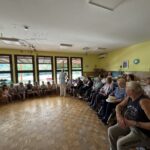 Otroci in stanovalci sedijo v sobi.