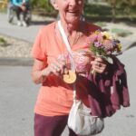 Ženska drži medaljo in šopek cvetja.